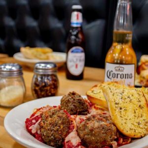 Table at Ledgens Pizza restaurant in Texas with spaghetti and homemade meatballs, Corona beer and garlic toast bread