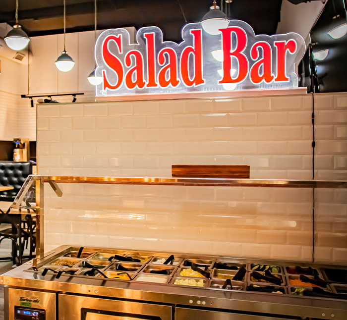 Salad Bar from ledgens pizza in Midland texas, the best salad bar buffet loaded with lettuce, spinach, tomato, olives, croutons, cranberries, potato salad, banana peppers, onions, cottage cheese, bacon bits, cheese, and dressing